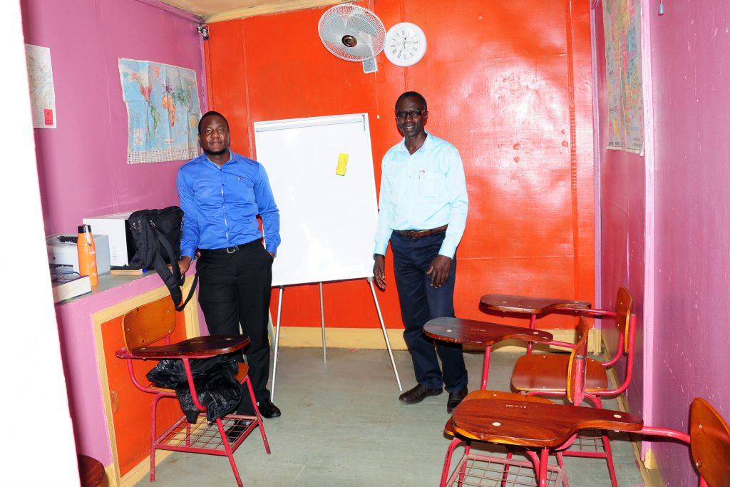 Two men standing in a classroom